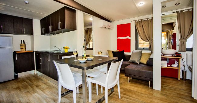 Cucina moderna con tavolo e sedie bianche.