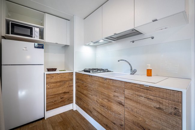 Cucina compatta con forno a microonde e frigorifero.