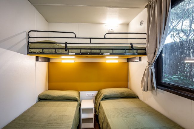 Camera con letto a castello e due letti singoli.