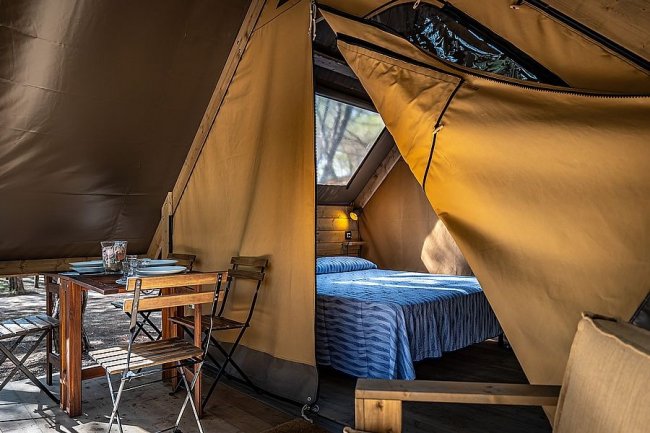 Interno di tenda glamping con area pranzo.