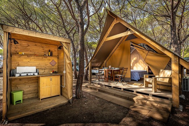 Cucina esterna accanto a tenda accogliente.