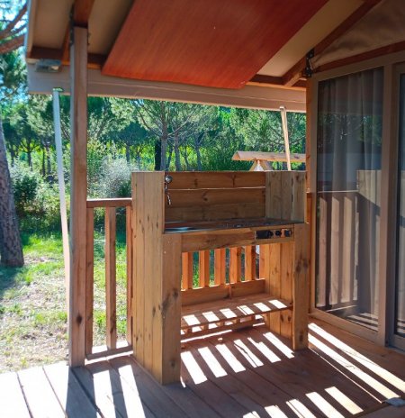 Cucina all'aperto in legno sotto una tettoia.