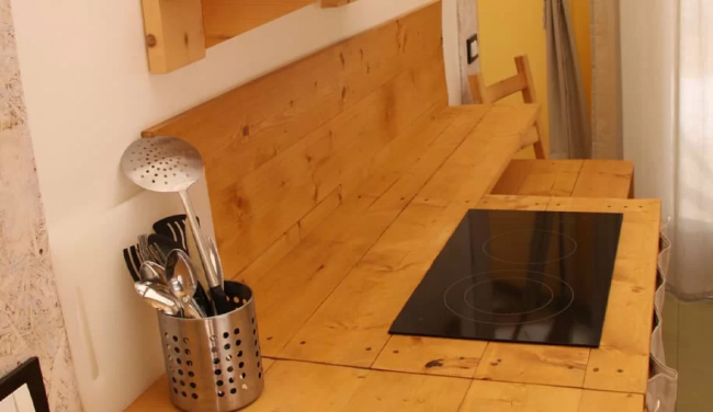 Cucina in legno chiaro con fornelli neri.