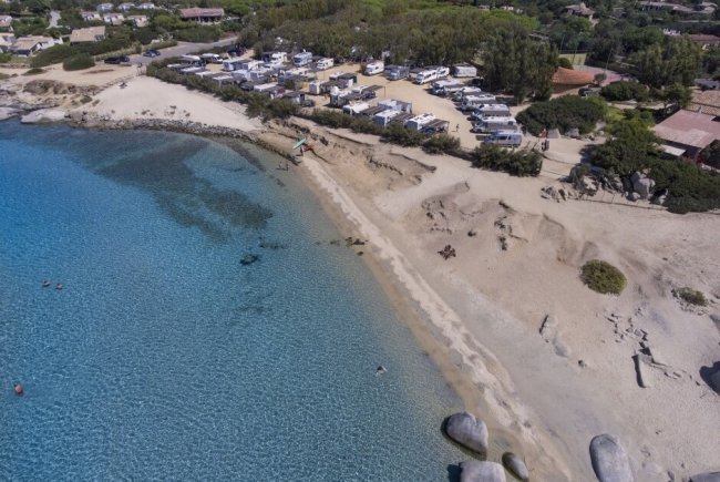 Spiaggia e mare limpido con camper vicini.