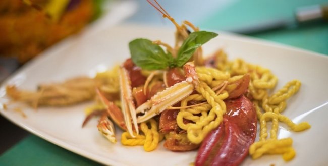 Piatto di pasta con frutti di mare e basilico.