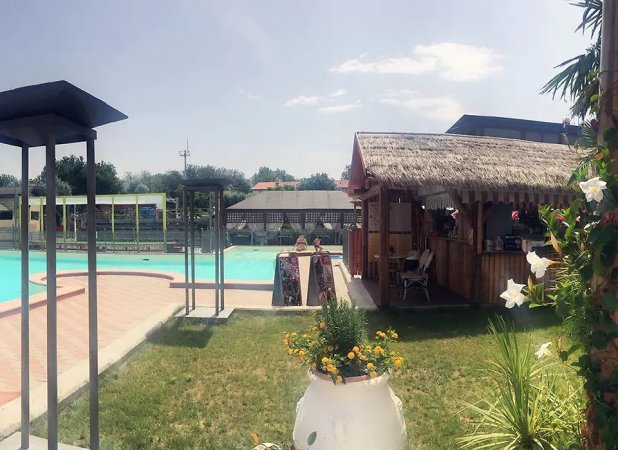 Piscina all'aperto con chiosco in legno.