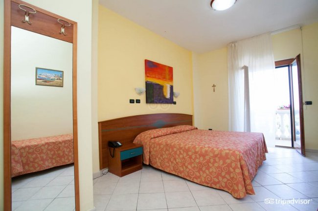 Camera d'hotel con letto matrimoniale e balcone.