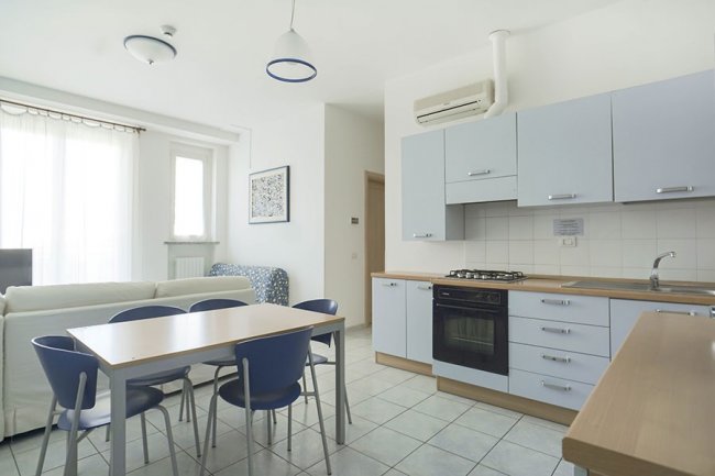 Cucina moderna con tavolo in legno e sedie blu.