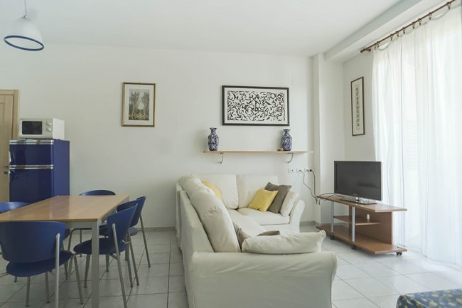 Soggiorno con divano bianco e TV.