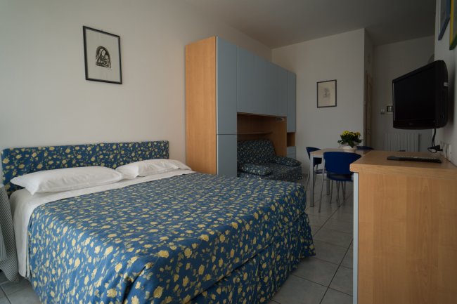 Camera da letto con letto matrimoniale e mobili blu.