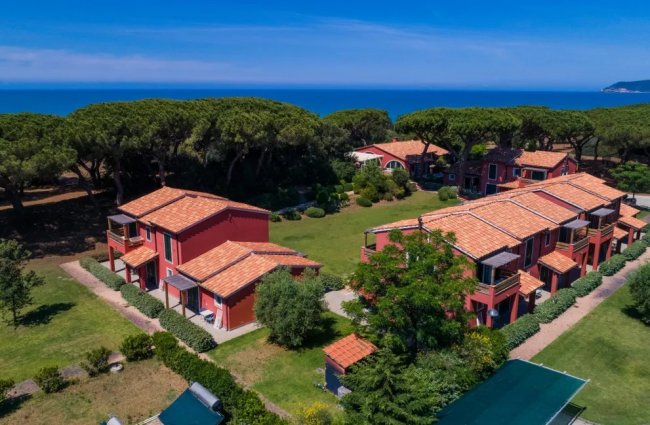 Complesso di edifici rossi con tetti a tegola, vicino al mare.