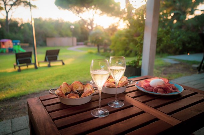 Tavolo con spuntini e calici di vino.
