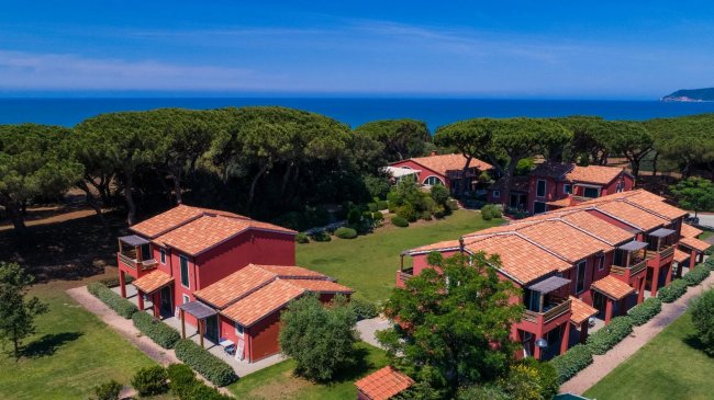 Complesso turistico con tetti rossi e giardino.