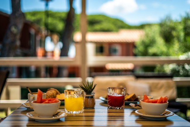 Colazione con frutta e succhi su un tavolo all'aperto.