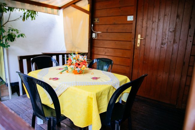Terrazza con tavolo giallo e sedie nere.