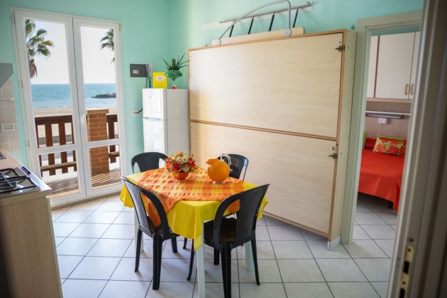 Cucina con vista mare e tavolo rotondo.