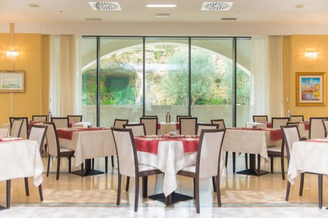 Sala da pranzo con tavoli apparecchiati.
