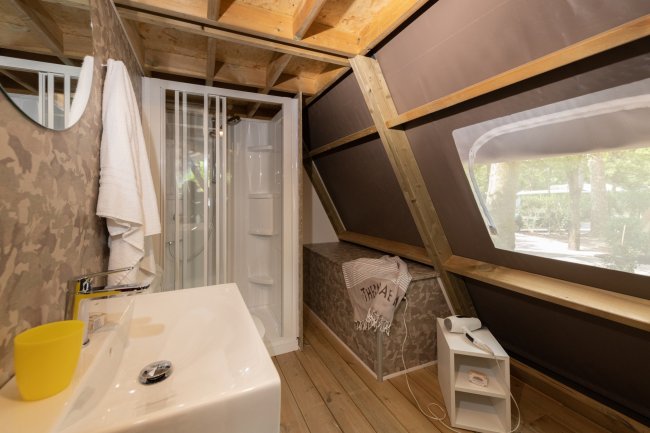 Interno rustico con doccia e lavabo.