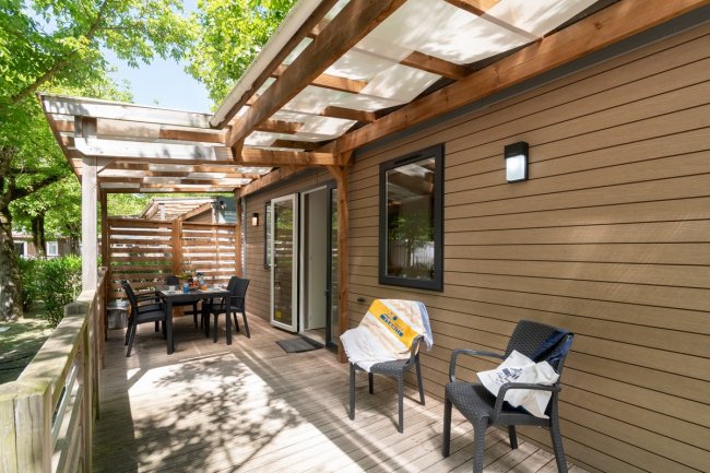 Terrazza con tavolo e sedie sotto pergola.