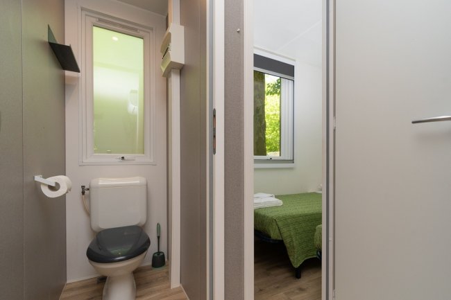 Bagno con finestra e vista su camera da letto.