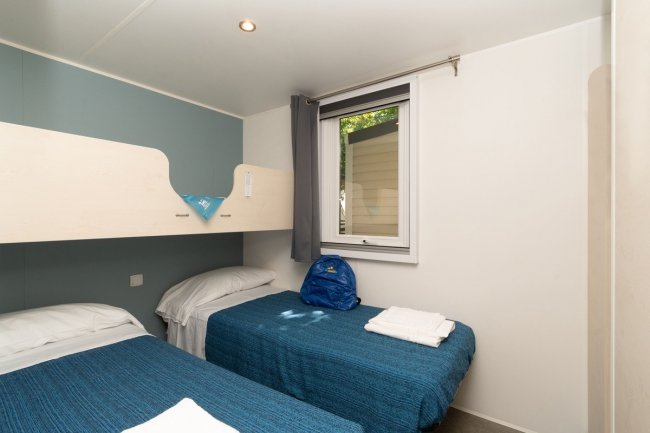 Camera con due letti singoli e finestra.