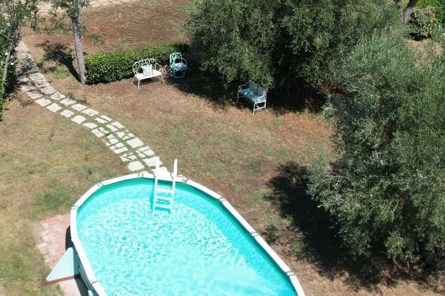 Piscina ovale con sentiero di pietra accanto.
