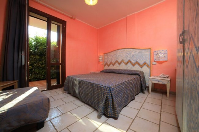 Stanza da letto con pareti arancioni e letto matrimoniale.