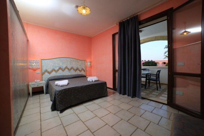 Camera da letto con letto matrimoniale e balcone.