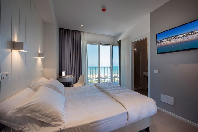 Camera d'hotel moderna con vista sul mare.