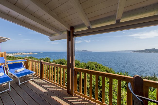 Terrazza in legno con vista mare e sedie blu.