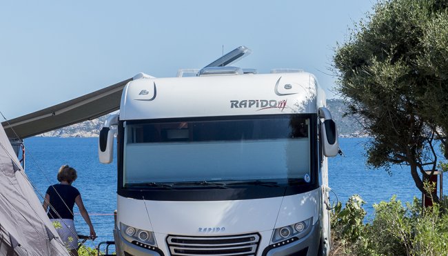 Camper bianco parcheggiato fronte mare.