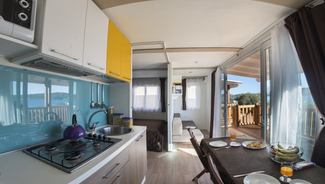 Cucina moderna con vista su una terrazza e paesaggio marino.