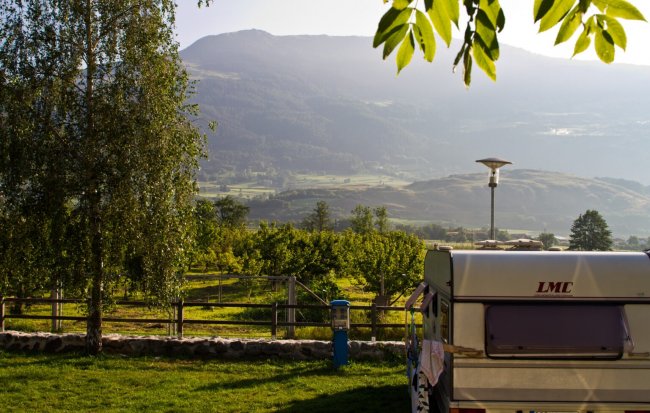 Una roulotte in un campeggio con vista sulle montagne.
