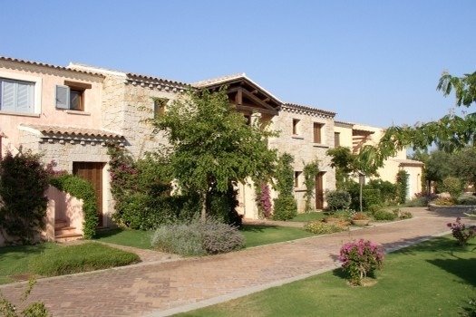 Edifici in pietra con giardino alberato.