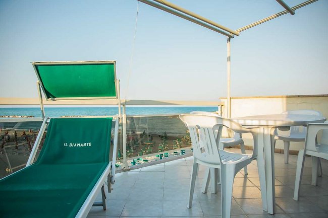 Solarium con lettino, tavolo e vista mare.