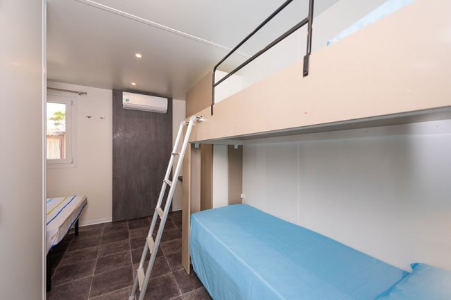 Stanza con letti a castello e scala.