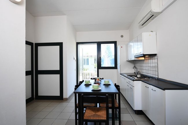 Cucina moderna con tavolo e sedie nere.