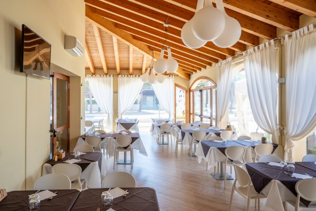 Ristorante luminoso con tavoli apparecchiati.