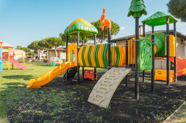 Parco giochi con scivoli arancioni e gialli.