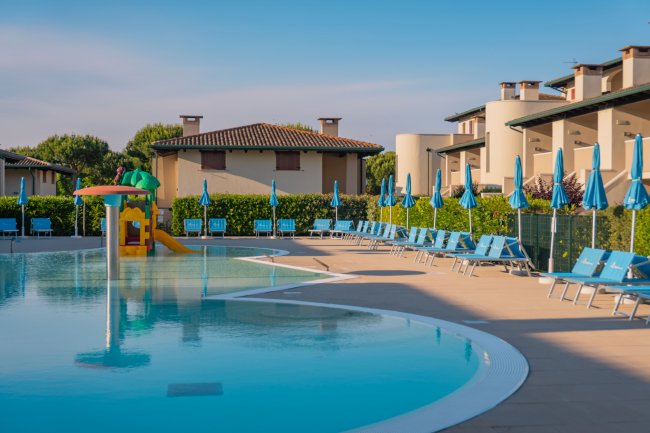 Piscina con ombrelloni e lettini blu.
