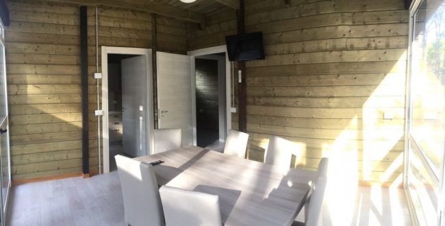 Stanza luminosa con tavolo e sedie.