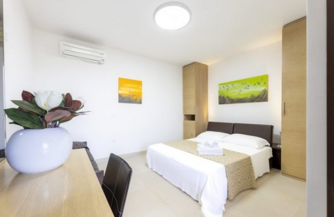 Stanza con letto doppio e vasi decorativi.