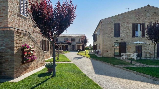 Cortile con edifici in mattoni e alberi.