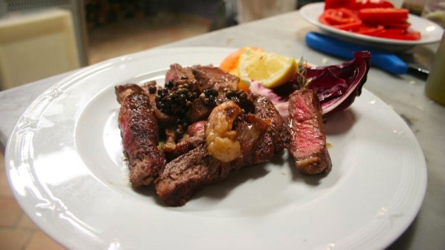 Piatto di carne con contorno di verdure e limone.