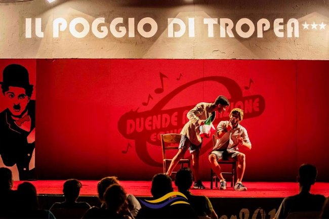 Esibizione teatrale su un palco rosso.