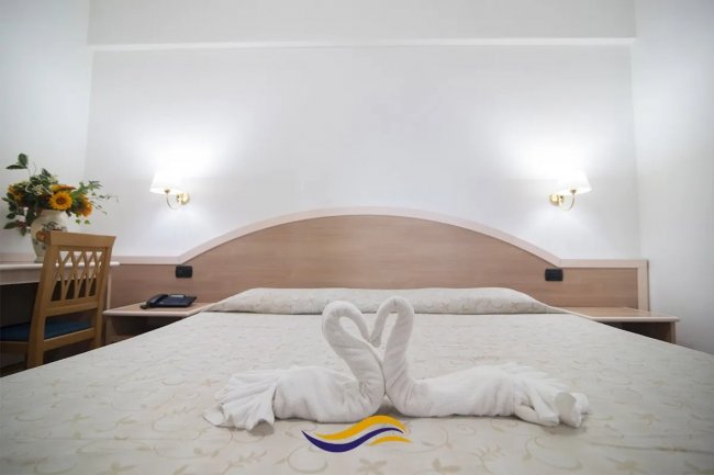 Letto matrimoniale con asciugamani a forma di cigni.