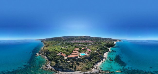 Vista aerea di un resort sul mare con piscine.