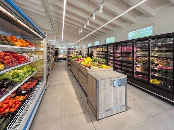 Interno di un negozio di alimentari con frutta e verdura esposta.