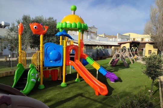 Area giochi colorata con scivoli e giochi.