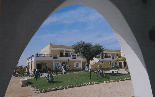 Edificio giallo visto attraverso un arco.